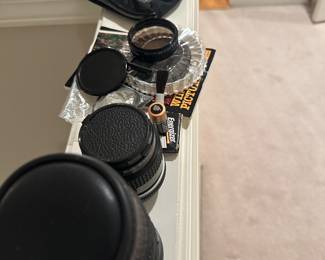collection of vintage camera lenses and accessories