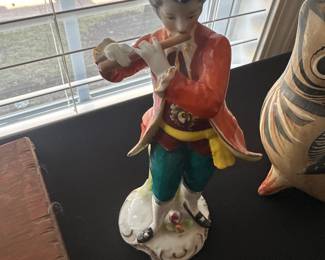 porcelain figurine of a colonial man playing a flute