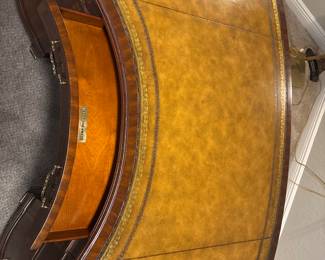 Maitland-Smith Regency Style inlayed Mahogany oval  desk with pristine hand tooled leather writing surface.                                                                                                          28" H 63 1/2" W X 26" D          