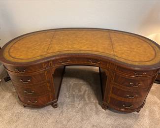 Maitland-Smith Regency Style inlayed Mahogany oval  desk with pristine hand tooled leather writing surface.                                                                                                          28" H 63 1/2" W X 26" D                                                                          