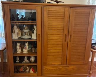 Entertainment center with sliding doors, a drawer and a glass cabinet door.  