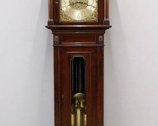 An early 20th century Waltham grandfather clock retailed by Tiffany & Co. New York.  8-day weight driven movement with quarter hour chiming on nine Waltham stamped tubular bells, arched Brass dial with engraved filigree design, Silvered chapter ring with Arabic numerals, subsidiary seconds, "Strike/Silent" and "Oxford/Whitington/Westminster" dials, painted upper dial with moon phases, landscape and sailing ships, brass pendulum with Steel shaft.  Mahogany Neoclassical style case with carved detail features a hood with an arched, molded crown and turned finial above and conforming door frame flanked by turned columns and a waist door with shaped glass flanked by turned columns, on a paneled base with molded plinth.  Original finish with minor wear, slight dial wear, running when cataloged.  97" high overall.  ESTIMATE $2,000-3,000