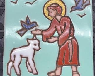 Handpainted religious ceramic tile depicting a saint with a lamb and birds.