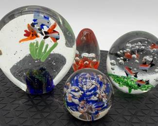 Collection of four decorative glass aquarium and millefiori paperweights.