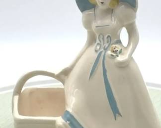 Vintage pottery figurine planter of a woman with a basket.