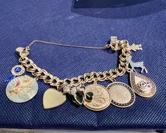 12 karat gold filled chain bracelet with 10, 12, and 14 gold filled charms and three Sterling charms