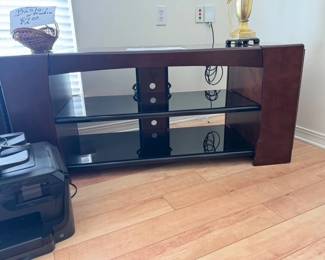 glass and wood entertainment center with glass shelving and storage on both ends