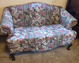Floral loveseat with clawfoot legs.