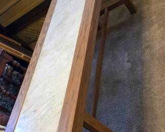 Handmade long wood table with marble slab insert.