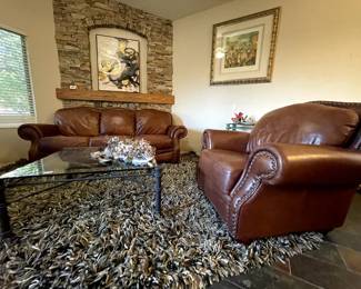 High-quality leather sofa and coordinating armchair, glass top coffee table, and shag rug from Crate and Barrel. More art coming this week to fill the walls!