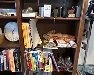 Assorted Books and Electronics on a Wooden Bookshelf