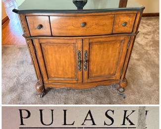 Pulaski Furniture console table featuring a dark top and decorative wood panels