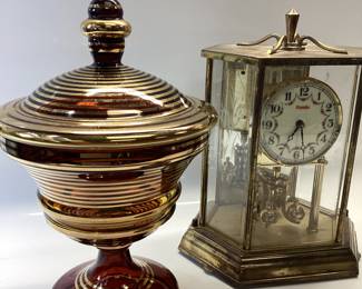 VINTAGE AMBER CANDY DISH WITH GOLD GILT, GOLD TONE PINEAPPLE COASTERS, GERMAN KUNDO BATTERY POWERED QUARTZ CLOCK, DABS OIL LAMP AND BRASS FOOTED PILLAR CANDLE HOLDER