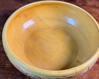 This lot features an antique bowl by Weller Pottery in their "Paragon" pattern, dating to the late 1920s. This bowl measures, 3.25” H x 9.75” W x 9.75” D. The Paragon line, introduced in 1931, is known for its woodcut-like floral motif, which is consistent with the design on your bowl. There is one very small hairline crack shown in photos.

