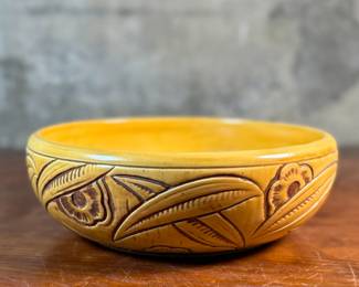 This lot features an antique bowl by Weller Pottery in their "Paragon" pattern, dating to the late 1920s. This bowl measures, 3.25” H x 9.75” W x 9.75” D. The Paragon line, introduced in 1931, is known for its woodcut-like floral motif, which is consistent with the design on your bowl. There is one very small hairline crack shown in photos.

