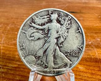 This lot features a 1943 Walking Liberty Half Dollar coin. The coin was issued by the United States Mint between 1916 and 1947. The design, created by Adolph A. Weinman, features Lady Liberty walking toward the sun carrying a bundle of branches. The coin has a composition of 90% silver and 10% copper. 

