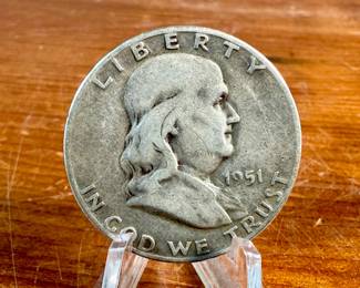 This lot features a 1951 Franklin Half Dollar coin. The coin was minted from 1948 to 1963 and features Benjamin Franklin on the obverse (front) and the Liberty Bell on the reverse (back). It is composed of 90% silver and 10% copper, with a reeded edge.

