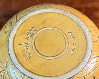 This lot features an antique bowl by Weller Pottery in their "Paragon" pattern, dating to the late 1920s. This bowl measures, 3.25” H x 9.75” W x 9.75” D. The Paragon line, introduced in 1931, is known for its woodcut-like floral motif, which is consistent with the design on your bowl. There is one very small hairline crack shown in photos.

