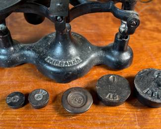 This lot features an antique Fairbanks cast iron balance scale with a brass scoop pan/hopper and a separate platform for weights (included). This scale (without hopper) measures, 9” H x 16” W x 5” D.

