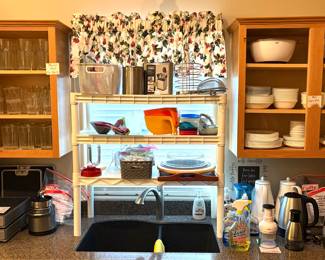 A collection of highball drinking glasses. White Corelle dinnerware items, two manual food choppers, and two electric kettles. 