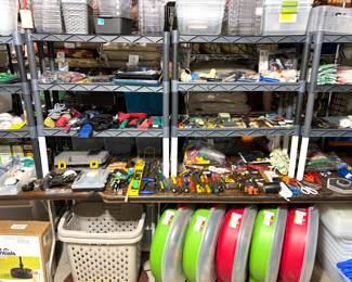 An assortment of hand tools including screwdrivers, pliers, utility knives, tape measures, levels, and safety equipment. Wreath storage containers, plastic shelving organizers and plastic storage containers. 