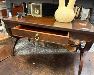 Antique wood coffee table with leather top covered with glass
