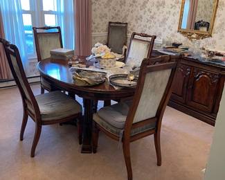 Beautiful dining room table. Comes with leaves and six chairs. Server and gold mirror pictured in the background