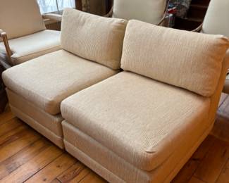 a pair of armless club chairs in the style of Milo Baughman