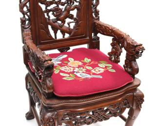 Pair of Wooden Dragon Chairs. These heavily carved wooden Asian chairs feature dragon heads on the end of the armrest. Also a bat, demons, and floral designs