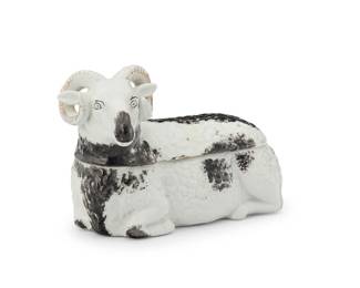 1135
A Kuznetsov porcelain figural box
Circa 1891-1917
With blue Duvelo factory mark
The lidded box in the form of a black and white ram, with gilt horns
4.5" H x 6.75" W x 3.375" D
Estimate: $400 - $600