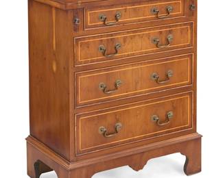 1182
A George III style mixed wood bachelor's chest
Mid-20th century
Stamped verso: Reprodux / Made in England
With flip-top on pull-out supports above four drawers and raised on bracket feet
Stored: 31.5" H x 23.5" W x 14" D; Open: 27.75" D
Estimate: $300 - $500