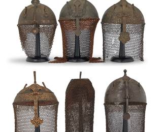 1120
A group of Islamic 'Turban' gilt metal and chain mail helmets
17th/18th century
Comprising five turban and/or 'Khula Khud'-style spiked iron and mixed metal helmets in various shapes and styles, each with a nose guard, two plume holders and a chain mail neck guard or 'aventail' of various gauges attached to the helmet edge, the helmets variously decorated with elaborate chased floral arabesque designs and borders, with Arabic inscriptions, one with gilt metal floral highlights, and two with a padded interior and printed cotton floral lining, as well as a full-face chain mail hood with padded fur interior and triangular opening to front
6 pieces
Helmets: Largest: 22" H x 8.25" Dia. (including aventail); Smallest: 13.5" H x 8.25" Dia.; Hood: 17.5" H x 5.5" W (expandable)
Estimate: $800 - $1,200