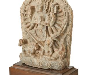 1107
A Nepalese stele of Durga slaying the demon Mahishasura
17th century
Durga standing with one foot on her tiger and the other on the buffalo body of Mahishasura, holding various weapons, with her trident aimed at the demon's heart, all within a flaming prabhamandala raised on a lotus pedestal, set in a custom wood plinth
Stone: 13.25" H x 8.5" W x 3.5" D; Plinth: 2.75" H x 10.25" W x 5" D
Estimate: $1,000 - $1,500