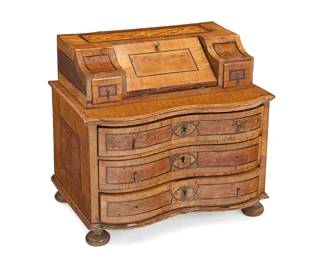 1223
A miniature German Baroque style marquetry desk
19th century
With two small drawers flanking a drop-front cabinet opening to reveal two small drawers and a letter cubby, above three locking drawers, decorated with foliate motifs, raised on bun feet
19.25" H x 21.25" W x 14.5" D
Estimate: $700 - $900