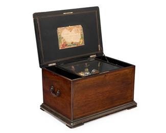 1229
A Swiss ten air theater music box
Late 19th/early 20th century
Appears unmarked
With three combs (21-12-23) and movement triggering bells with bee strikers, percussion, and two dancing figure automata, with Change/Repeat and Start/Stop switches, a 10.75" metal cylinder, and hand-written paper label to lid with music selection, housed in a wood case with marquetry lid
15.25" H x 26.75" W x 19" D
Estimate: $1,500 - $2,000