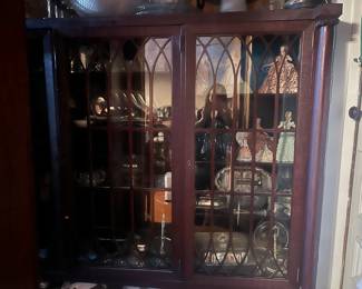 closet with sterling plated serving plates and porcelain dolls with lace 