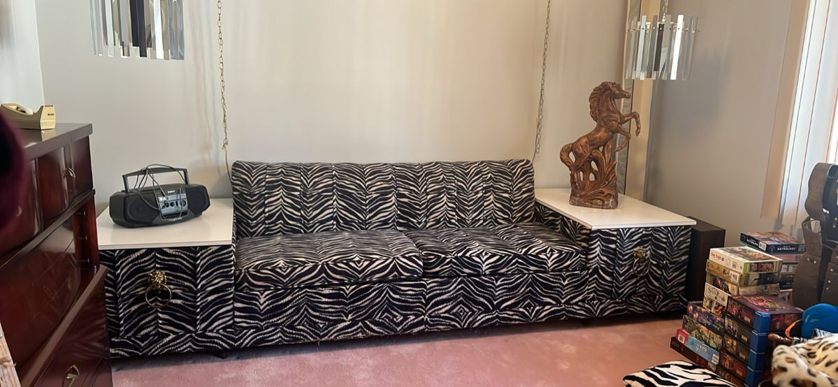 11 feet long by 32 inch deep Vintage zebra Castro convertible sofa bed with built-in end tables. The tops of the tables are bright white for Maika. The hardware on the pullout drawers is the iconic brass lion door knocker style. And of course, the drawers are lined in fabulous red flocking. It is truly an unusual piece and was custom-made in the late 60s early 70s.