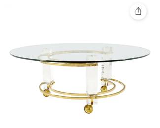 Charles Hollis Jones 42 inches round cocktail table on castors. Lucite pillars and brass C shaped accents. Very interesting Empire style triangular brass hardware. The matching PAIR of side tables is also available. Perfect set of 3 for a collector