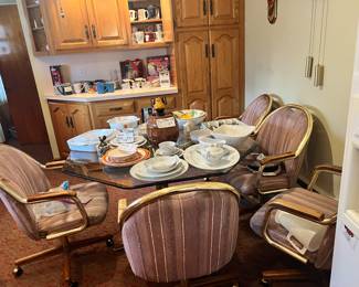 Darling glass, brass and wood dinette set. Comes with the matching six chairs on casters. 