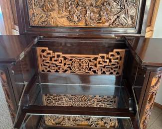 Mid-Century George Zee Asian hand-carved Chinoiserie dry bar cabinet with a flip top, side shelves and corner wine glass holders. 36" wide x 18"deep x 40" high.