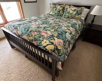 Queen-sized bed with matresses and side table.