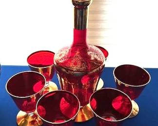 Mid-Century Ruby Red Glass decanter set with gold trim and motifs.