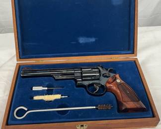 Features include a 6.5-inch barrel, blued finish, and checkered wooden grips