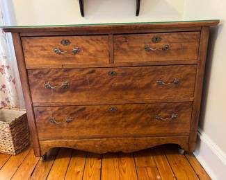 Soild wood four drawer chest of drawers with ornate brass hardware, including keyholes and bail pull handles. A scalloped bottom edge with small castors for mobility. Measures 33x43x21. Has a glass top covering for protection. In excellent condition with well functioning drawers. Drawers have dovetail joints.