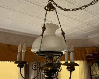 Brass chandelier 4 electric candle lights, ruffled top mild glass shade.