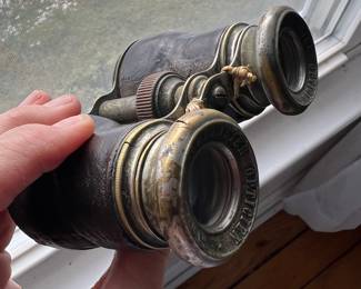 Antique Paris opera glasses/binoculars. Brass body with dark leather covering. Patina consistent with age.