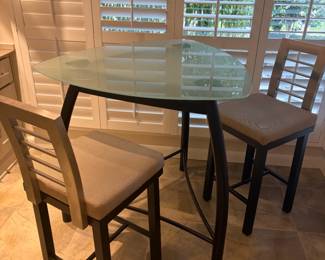 $280. Glass top metal base bar height triangular table with two stools.  