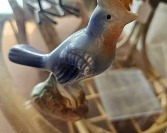 A vintage Royal Copley ceramic bird figurine perched on a branch.
