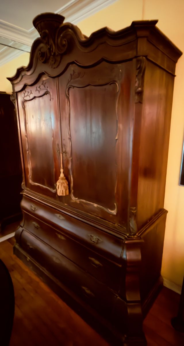 Elegant antique wooden armoire with intricate carvings and spacious drawers.