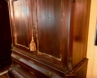 Elegant antique wooden armoire with intricate carvings and spacious drawers. 